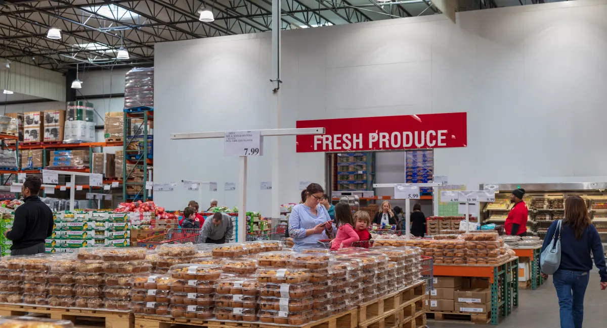 Customers browse a food retailer, with goods displayed on pallets and shelves