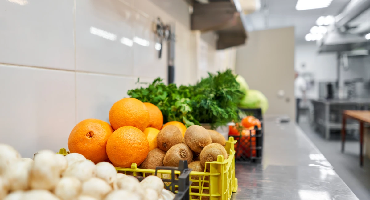 Fresh vegetables and fruit on silver steel table in a professional kitchen 